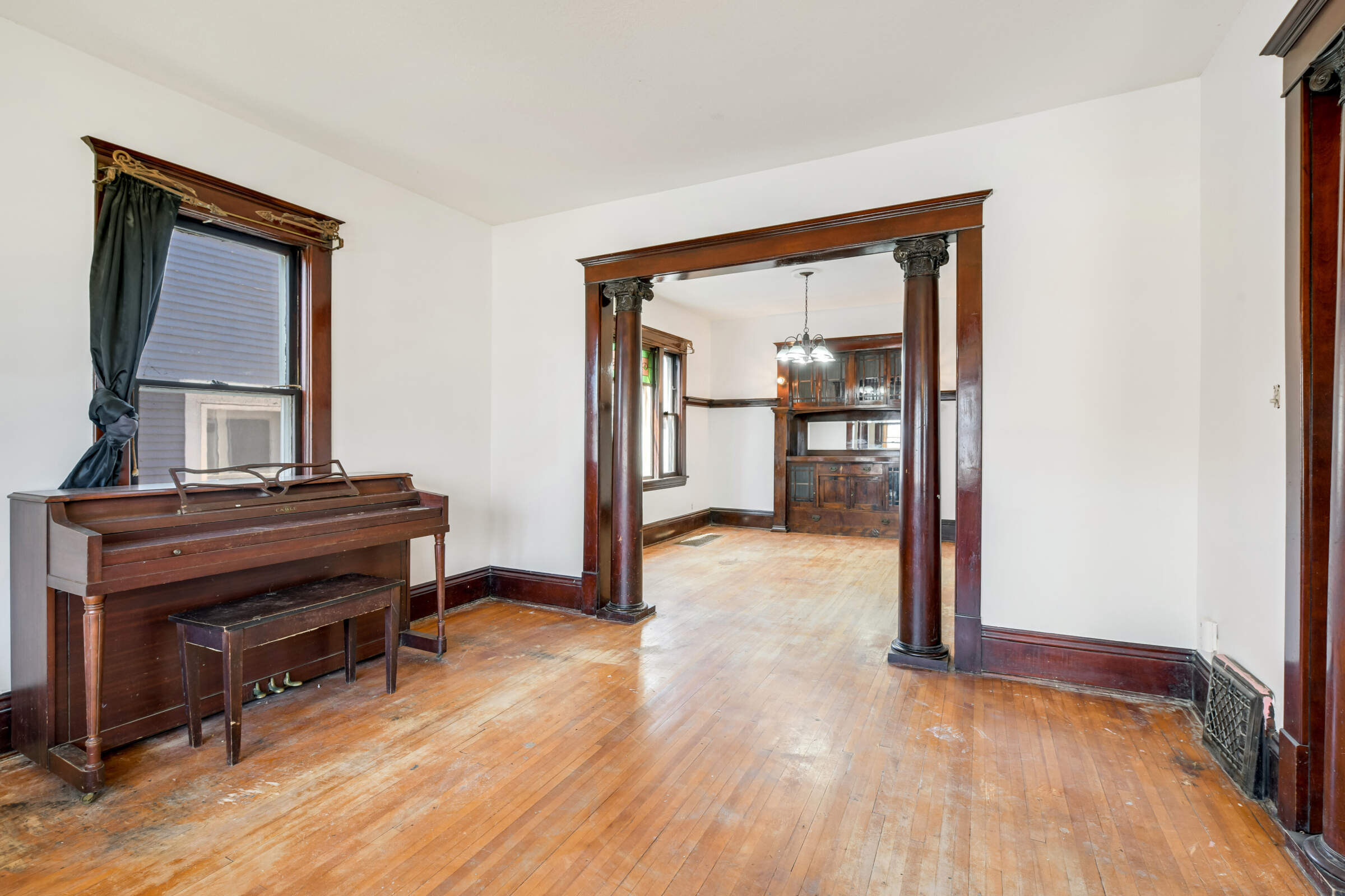 Stately columns between the living room and dining room frame the original built-in buffet